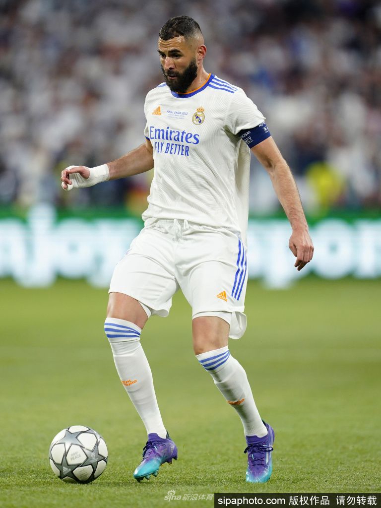 本泽马高举欧冠奖杯仰天怒吼，身后漫天银色纸屑如星辰般洒落，映照着他王者加冕的璀璨瞬间