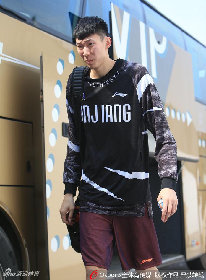 周琦左手拇指缠着厚厚的白色绷带,神情严峻地低头走入训练馆,眼神中透露出忍着剧痛的坚毅与对胜利的渴望。