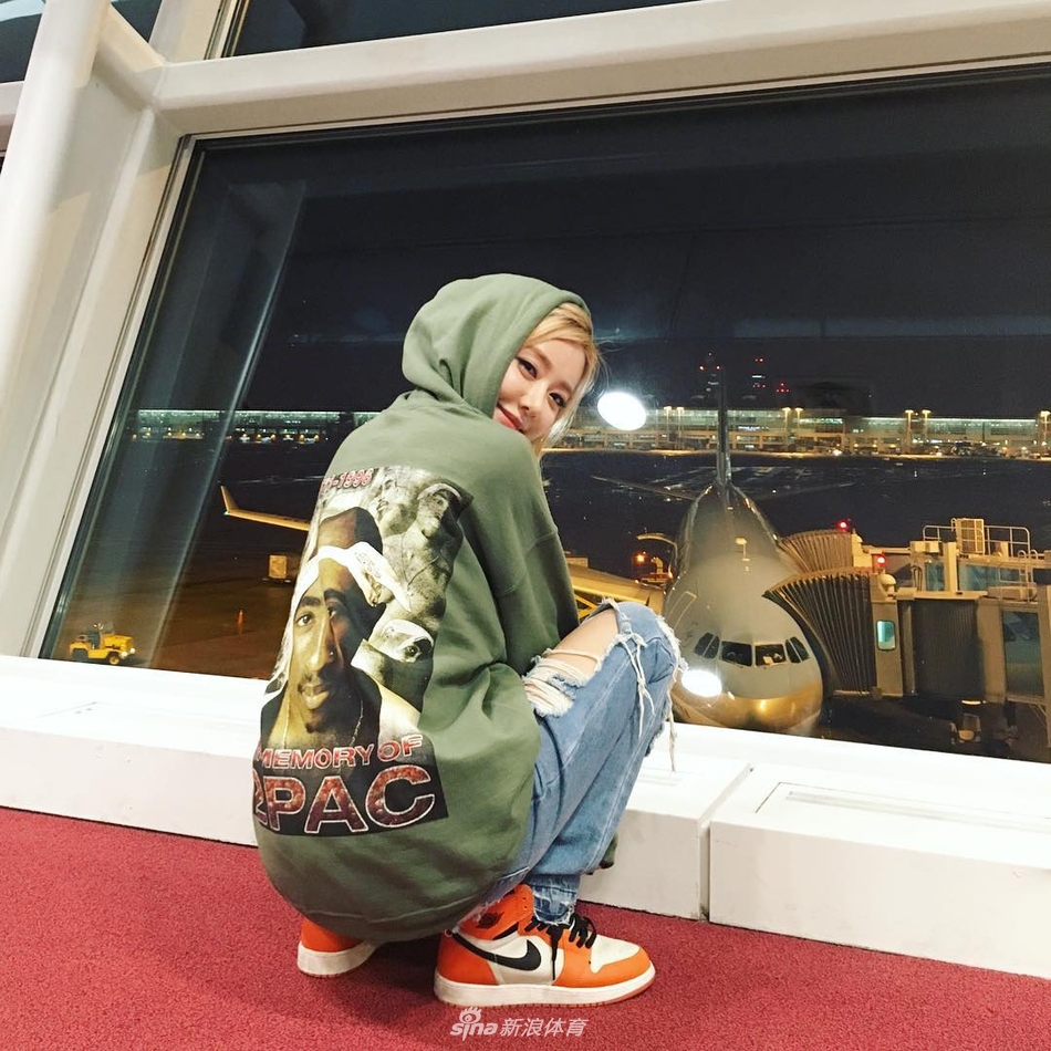 DJ Soda身穿紧身连衣裙,将一双Air Jordan球鞋抱在怀中,她低下头深情凝视着手中的鞋子,金色的头发遮住了半边脸,画面充满了女性魅力与对球鞋的温柔爱意。