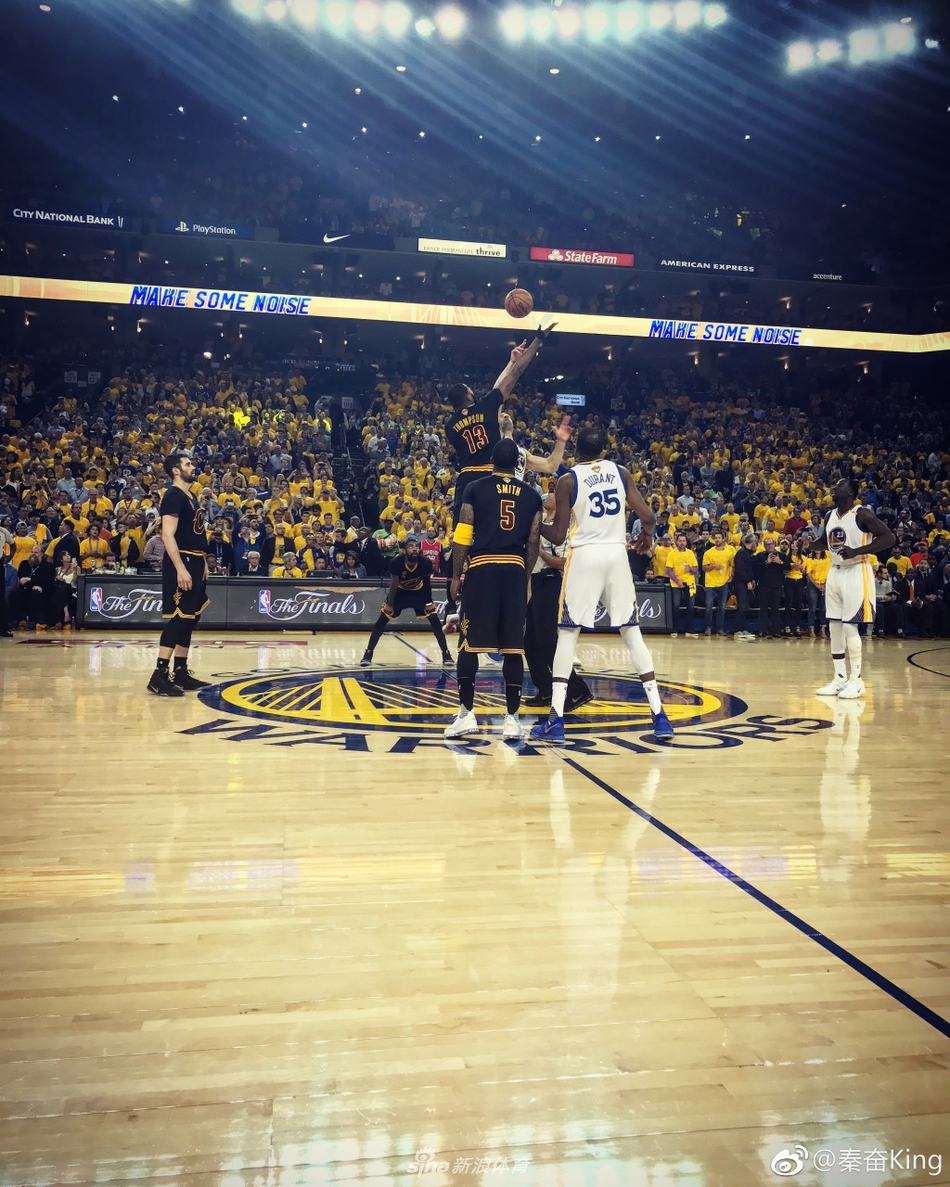 赛场边的秦奋正与友人交流，他戴着时尚的墨镜和棒球帽，面带微笑，轻松惬意，背景是热闹的球迷看台，仿佛将场边的奢华看球体验定格在了这一刻。