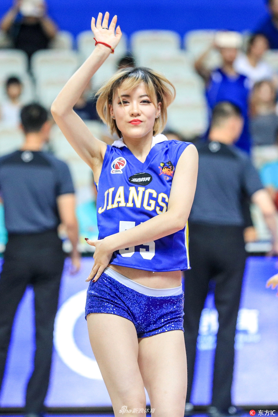 啦啦队员转身回眸,脸上洋溢着自信的笑容,手中的花球在灯光下闪耀着璀璨的光芒,青春活力感染全场。