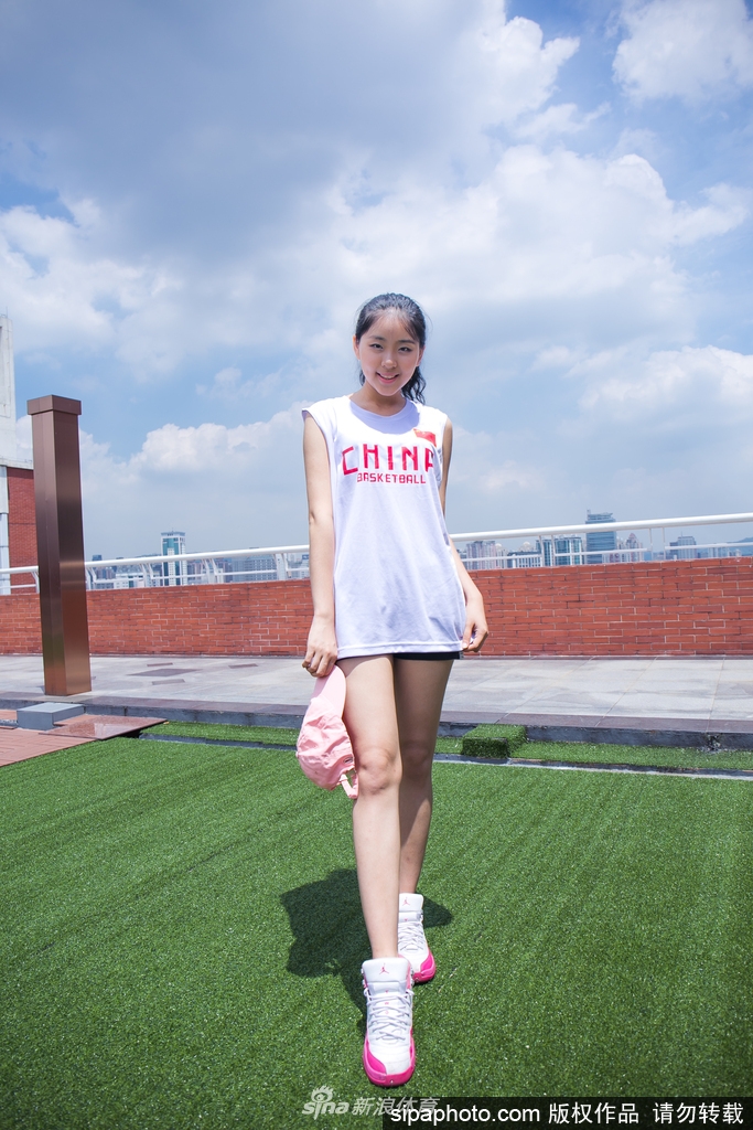 写真中的篮球宝贝换上一袭白色连衣裙，头戴时尚草帽，在光影交错中回眸，宛如夏日里的清新女神，既有着运动的活力，又不失女性的柔美。