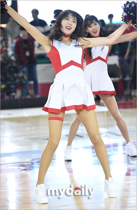 比赛高潮时刻,啦啦队员面对观众席绽放灿烂笑容,双手高举指向天空,调动全场球迷的欢呼情绪。