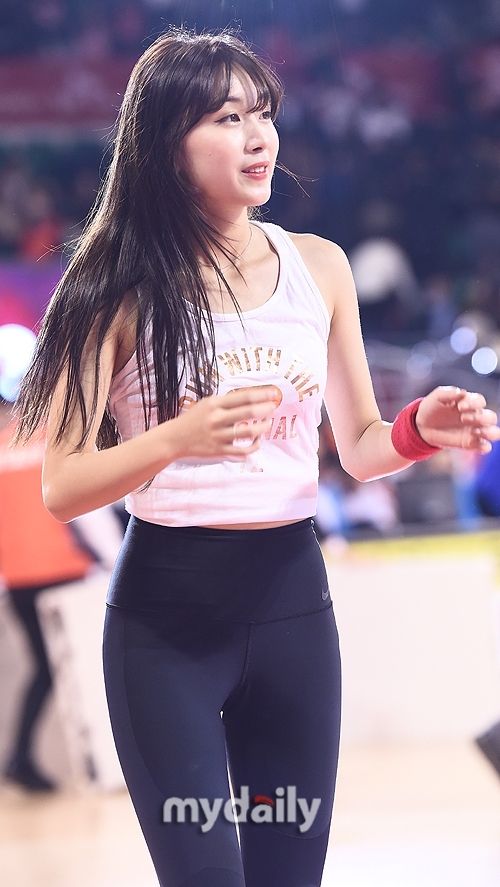 多名啦啦隊員一字排開，在球場邊線整齊劃一地舞動，充滿力量的動作展現出團隊的默契與熱情。