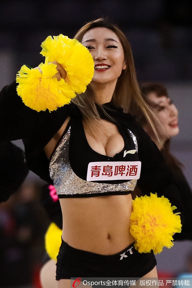 在蓝色灯光营造的梦幻氛围中,宝贝们变换队形,展现柔美身姿,仿佛海浪般此起彼伏,为硬朗的篮球场增添了一抹柔情。