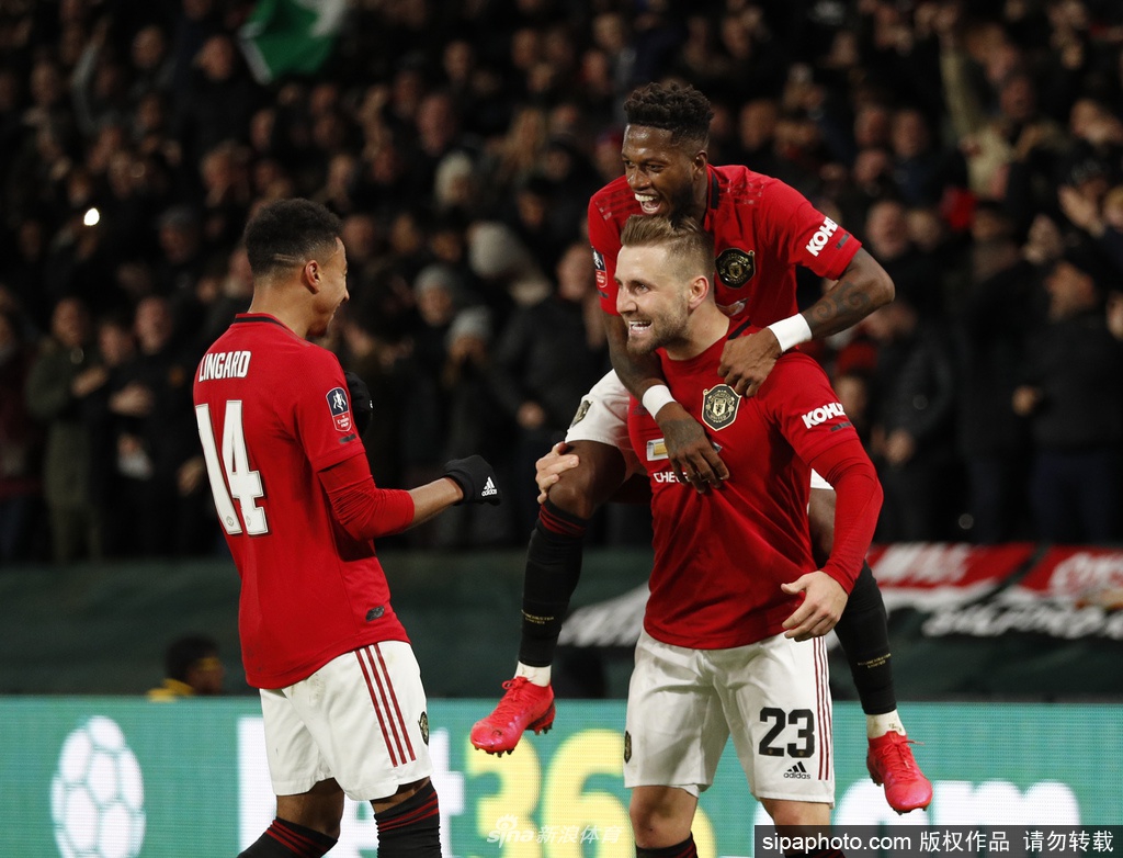 曼联队徽在空旷的老特拉福德球场前显得格外醒目，无声诉说着无球可踢的寂静与等待。