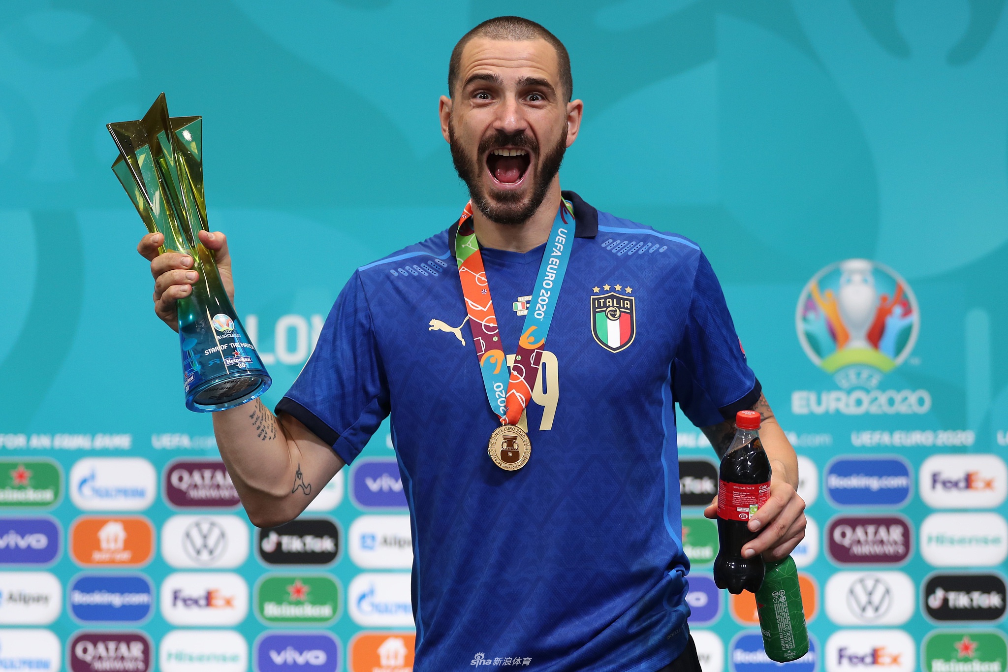 发布会接近尾声，博努奇整理着面前的啤酒和可乐瓶，背后的背景板上的赞助商标识清晰可见，他用自己的方式为赞助商做了一次完美的免费宣传。