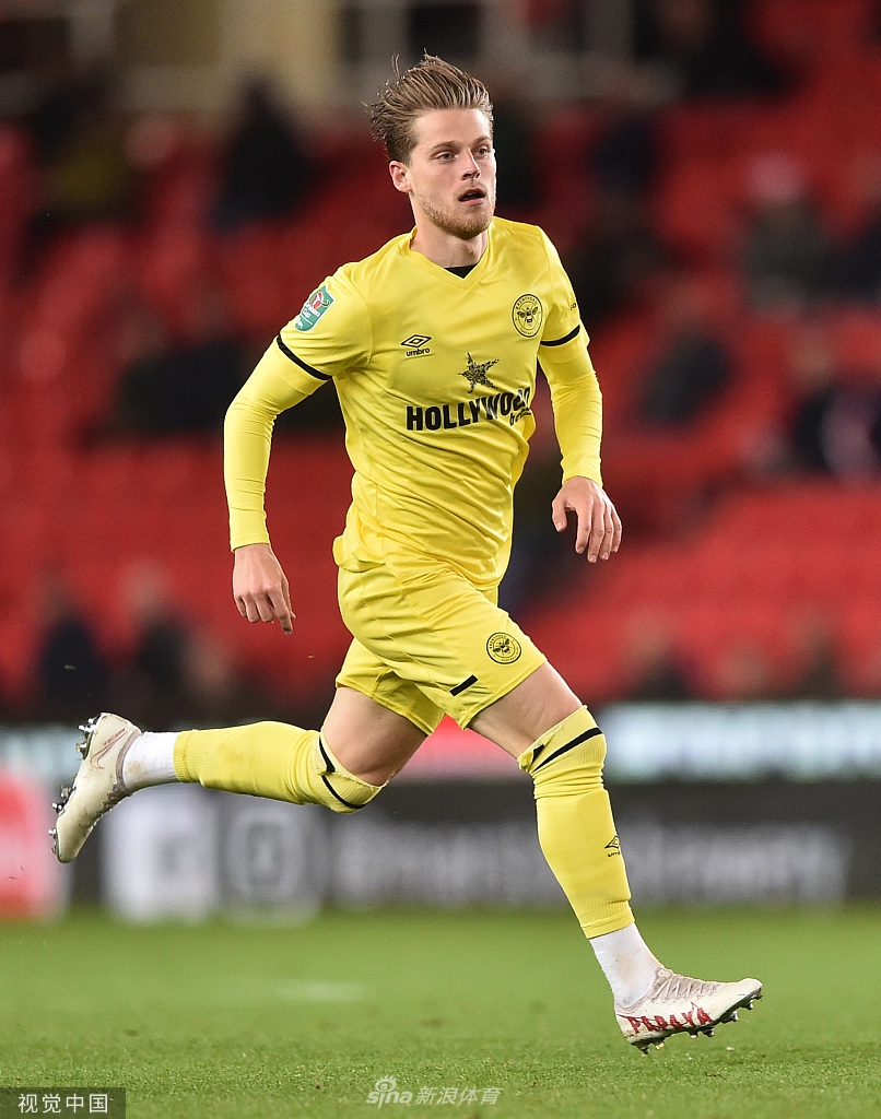 斯托克城的高大中卫在布伦特福德禁区内高高跃起争抢头球，客队防守球员寸步不让地紧贴防守，双方手臂纠缠，眼神坚定，这是力与力的直接碰撞，展现了比赛的残酷与激烈。