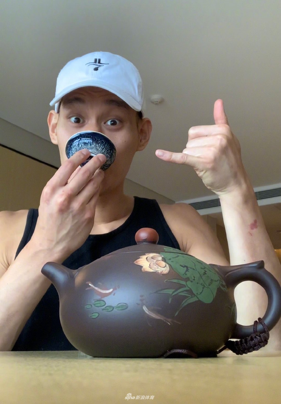 夕阳余晖中，林书豪独自坐在阳台茶桌前，提壶斟茶，背影显得平静而深邃，仿佛在与过去的自己对话，品味着篮球人生的苦尽甘来