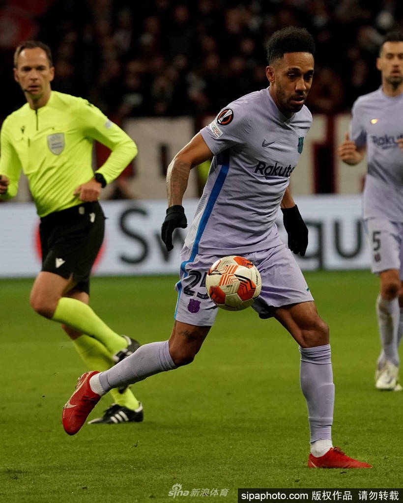 奥巴梅扬训练中专注控球，眼神坚定，背景是巴塞罗那训练基地