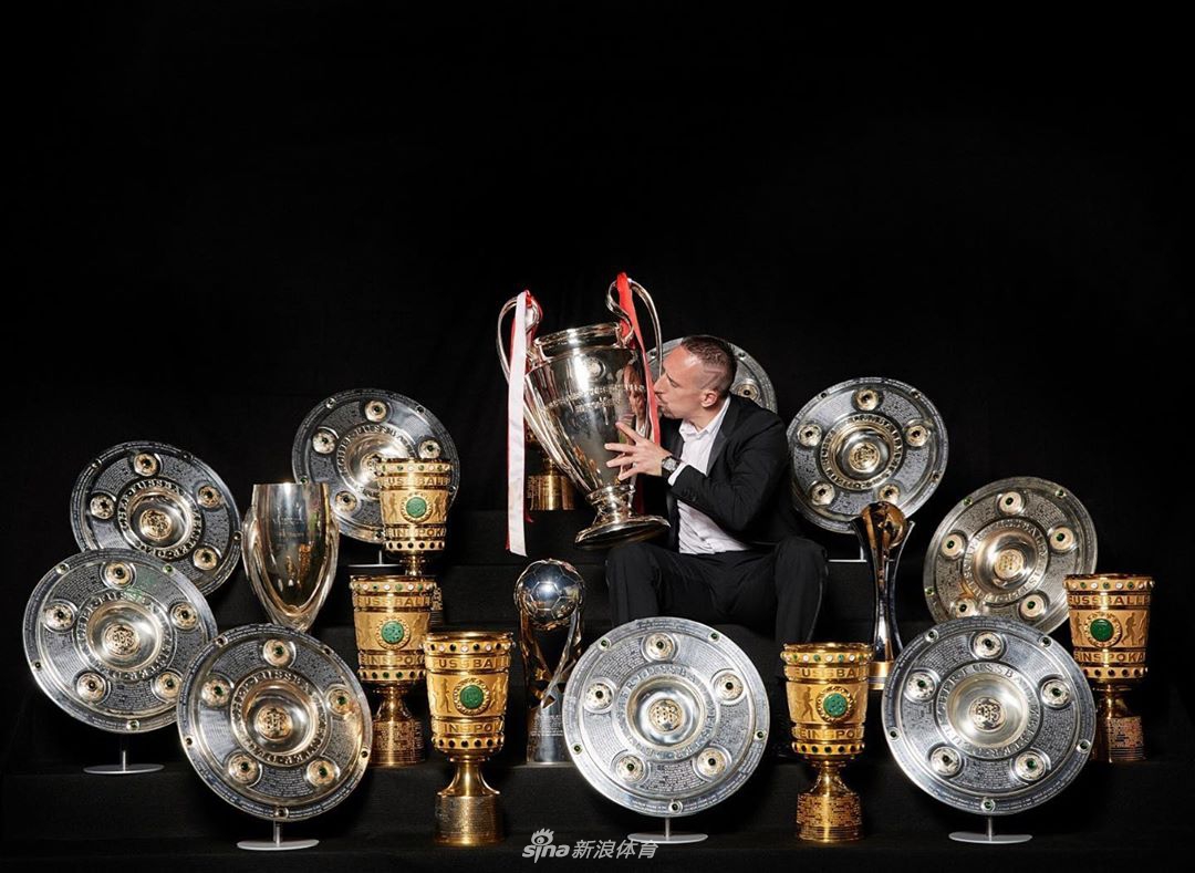 在慕尼黑市中心盛大的夺冠巡游上，罗本和里贝里站在敞篷大巴上，共同举起一座奖杯，与下方密密麻麻的球迷共享荣耀时刻。