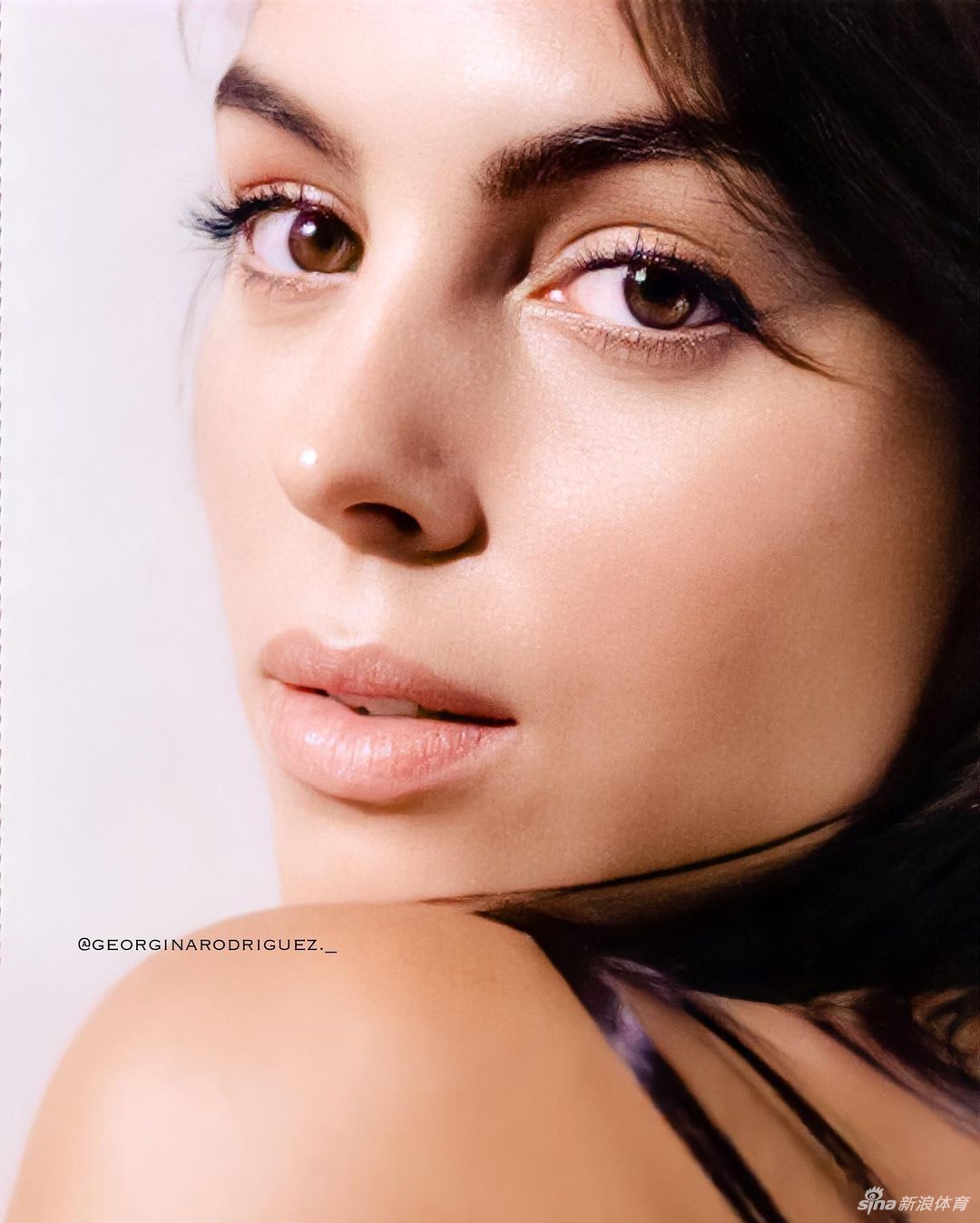 聚光灯下的乔治娜闪耀着明星光环，她与一位可爱的小女孩温馨互动，画面中充满了鼓励与关爱的氛围，展现了她在公众人物身份之外那颗真挚的公益之心。