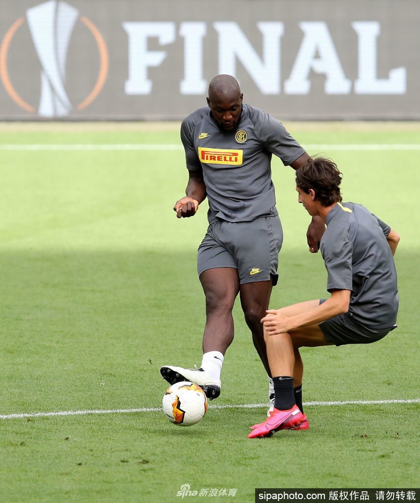 训练场上，主教练安东尼奥·孔蒂双手叉腰，神情严肃地注视着场上的一切，他身旁的助教正在战术板上写写画画，背景中球员们正在进行分组对抗，凸显了这位战术大师对每一个细节的严格要求。