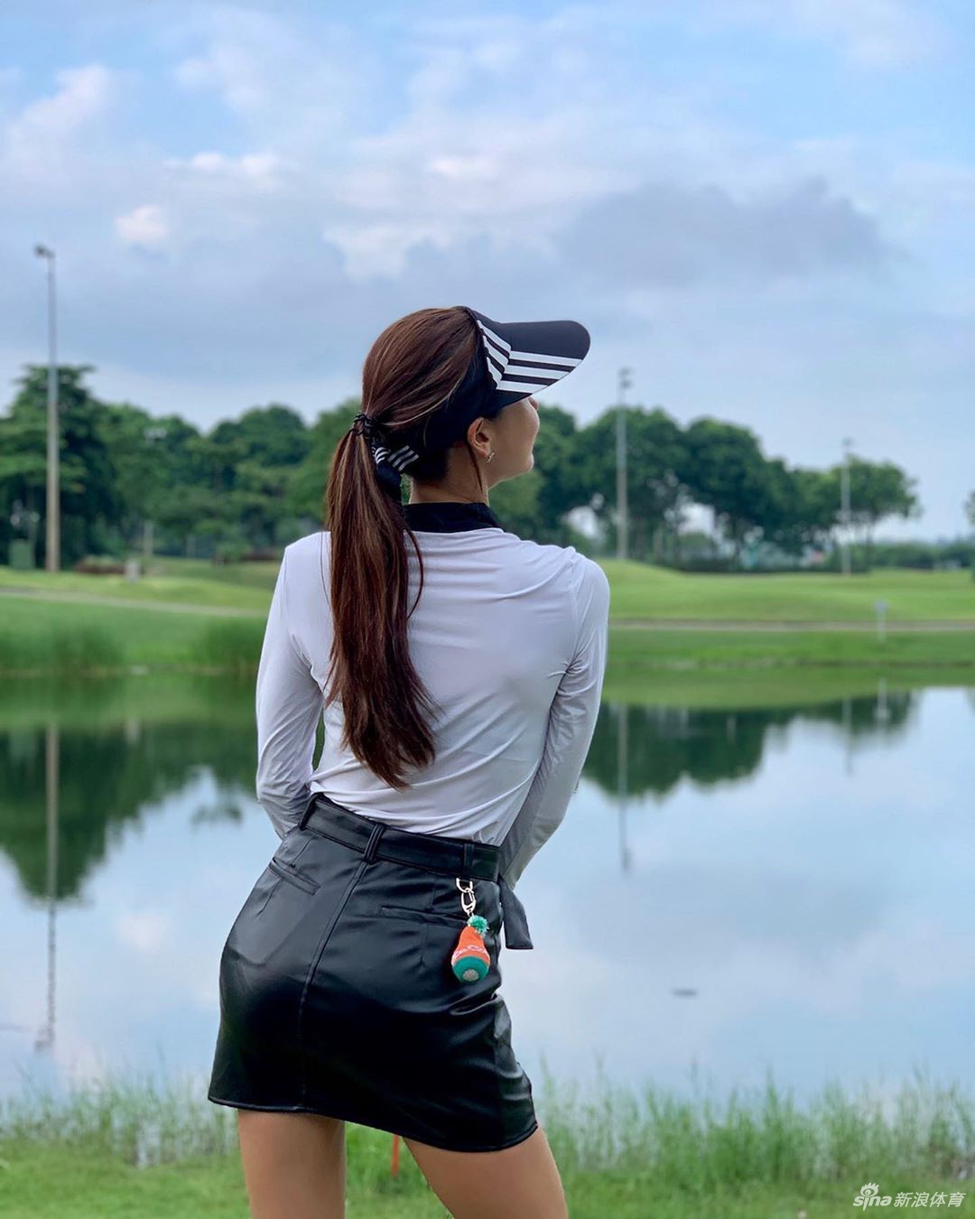 蹲身仔细观察果岭草纹与坡度，神情认真如研究者探索自然奥秘