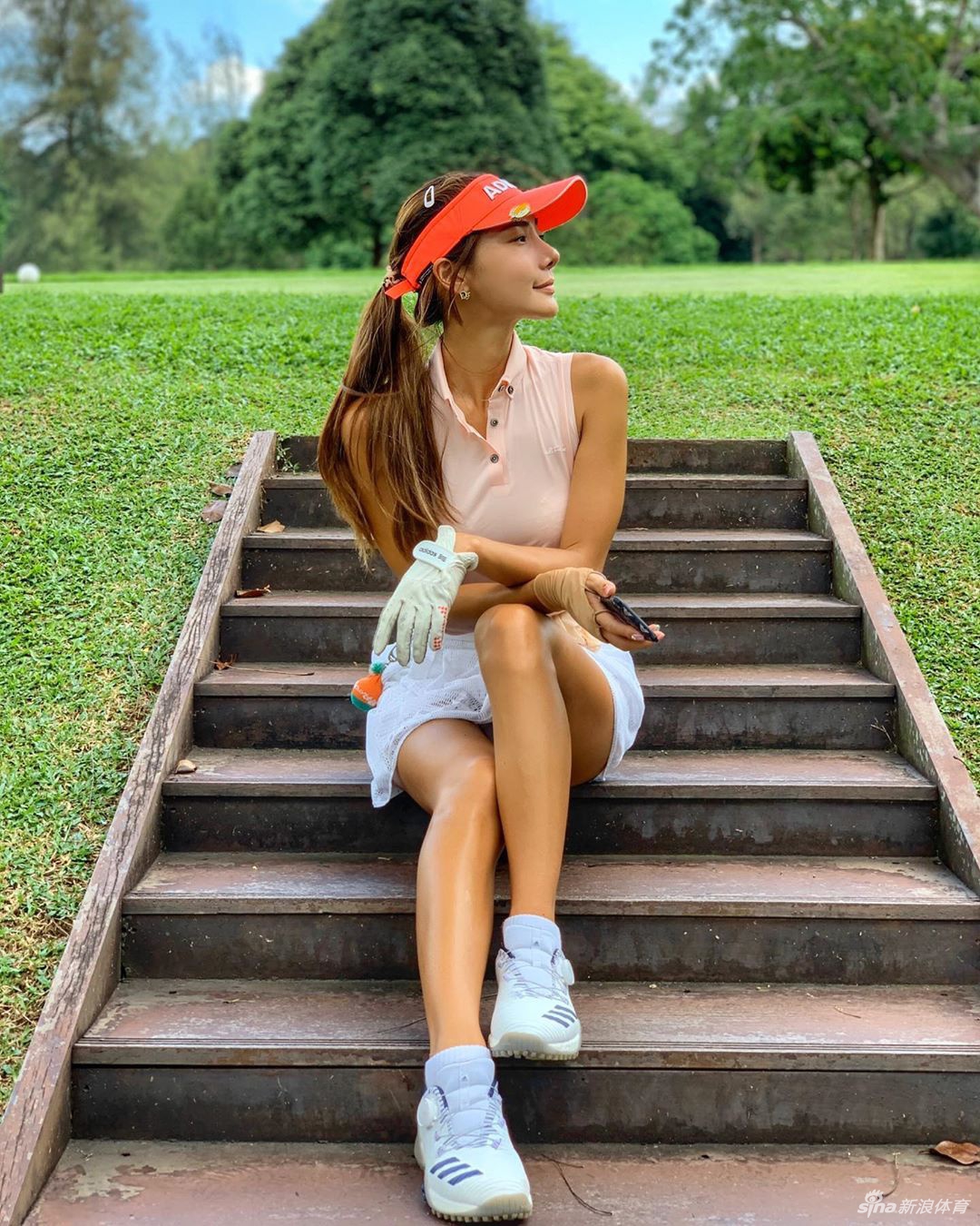 黄昏时分完成一轮练习，扛着球杆走向休息区，身影被拉长映在草地上，宁静而满足