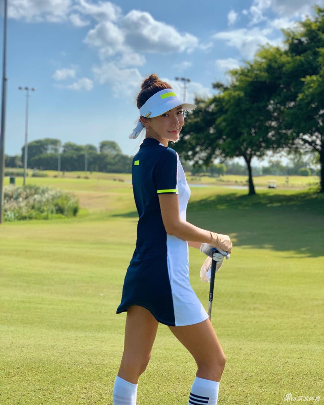 击球后优雅收杆，目光追随白色小球飞向远方，唇角带着自信的微笑