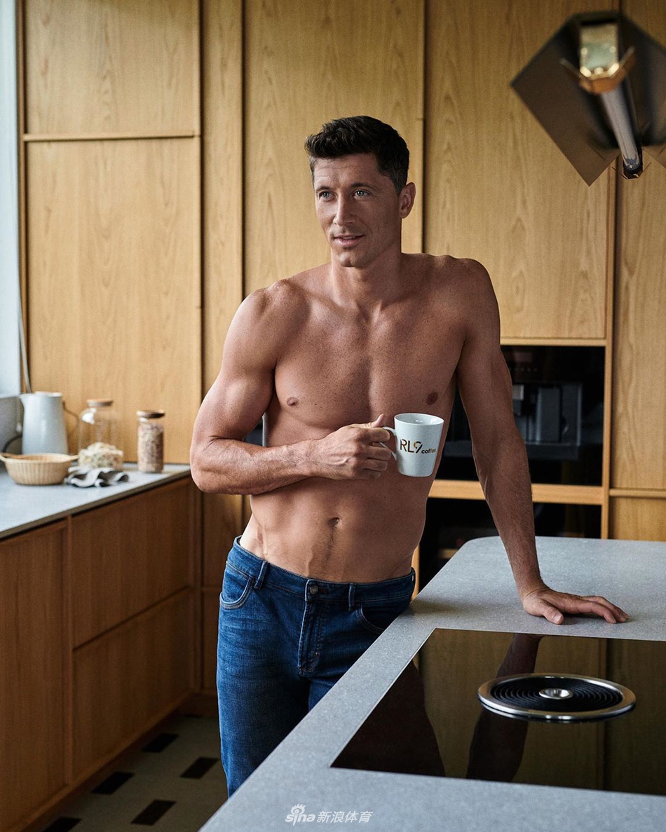 莱万在夕阳下的海边练习瑜伽动作，他单腿站立，双臂舒展，全身肌肉在拉伸下呈现出完美的线条，核心力量展现无遗，腹肌如同巧克力板块般排列，充满了力量与柔韧的美感。