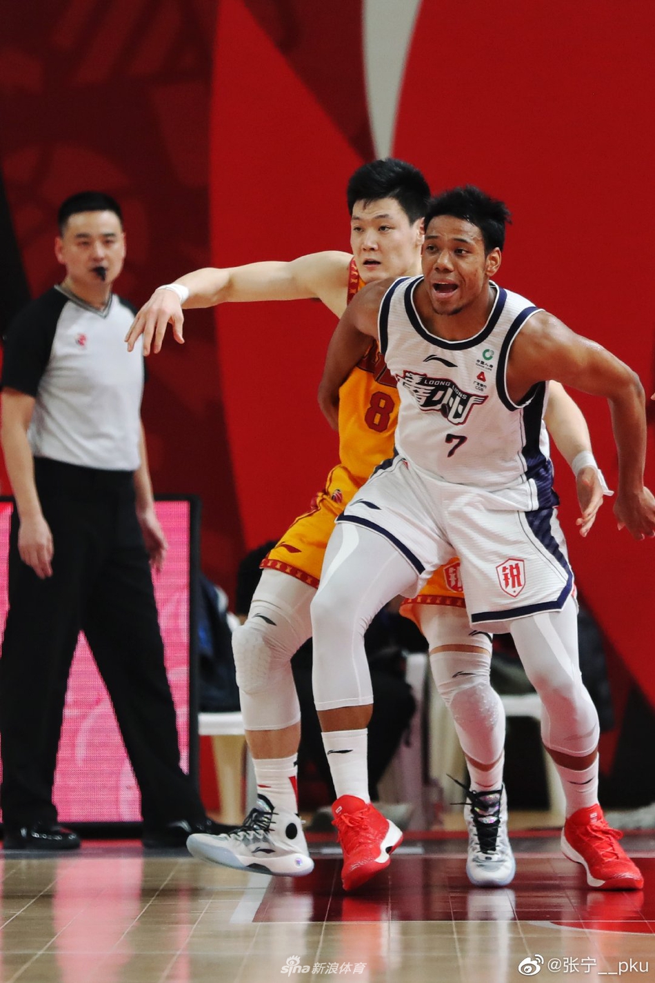 赛场上张宁持球突破，面对广州队的防守，眼神坚定，肌肉线条彰显着他在CBA历练后的成长与自信