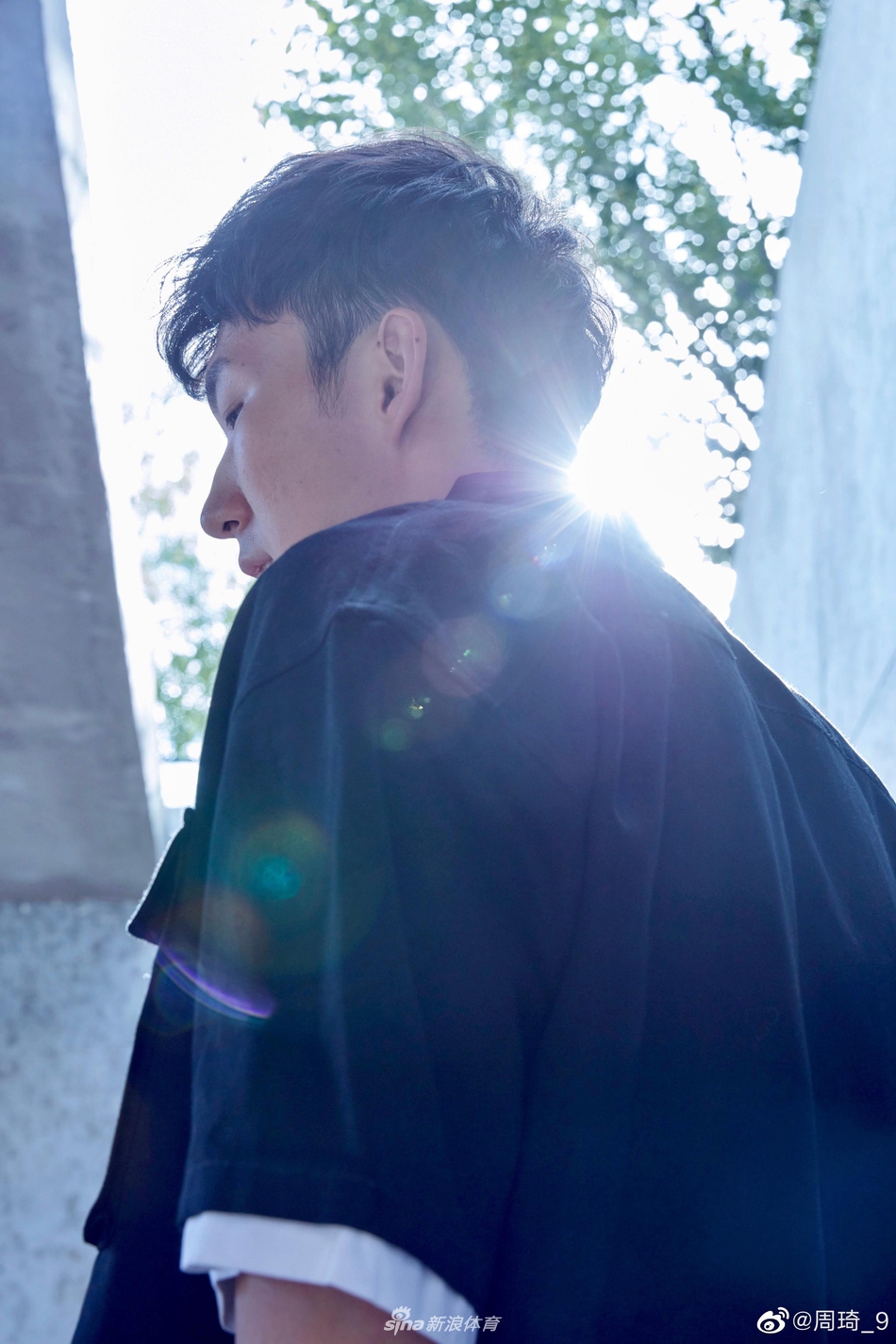 手机镜头捕捉到周琦望向镜头的瞬间，嘴角挂着淡淡的笑意，身后的房间虽未言明，却仿佛藏着他对生活最温柔的期许。