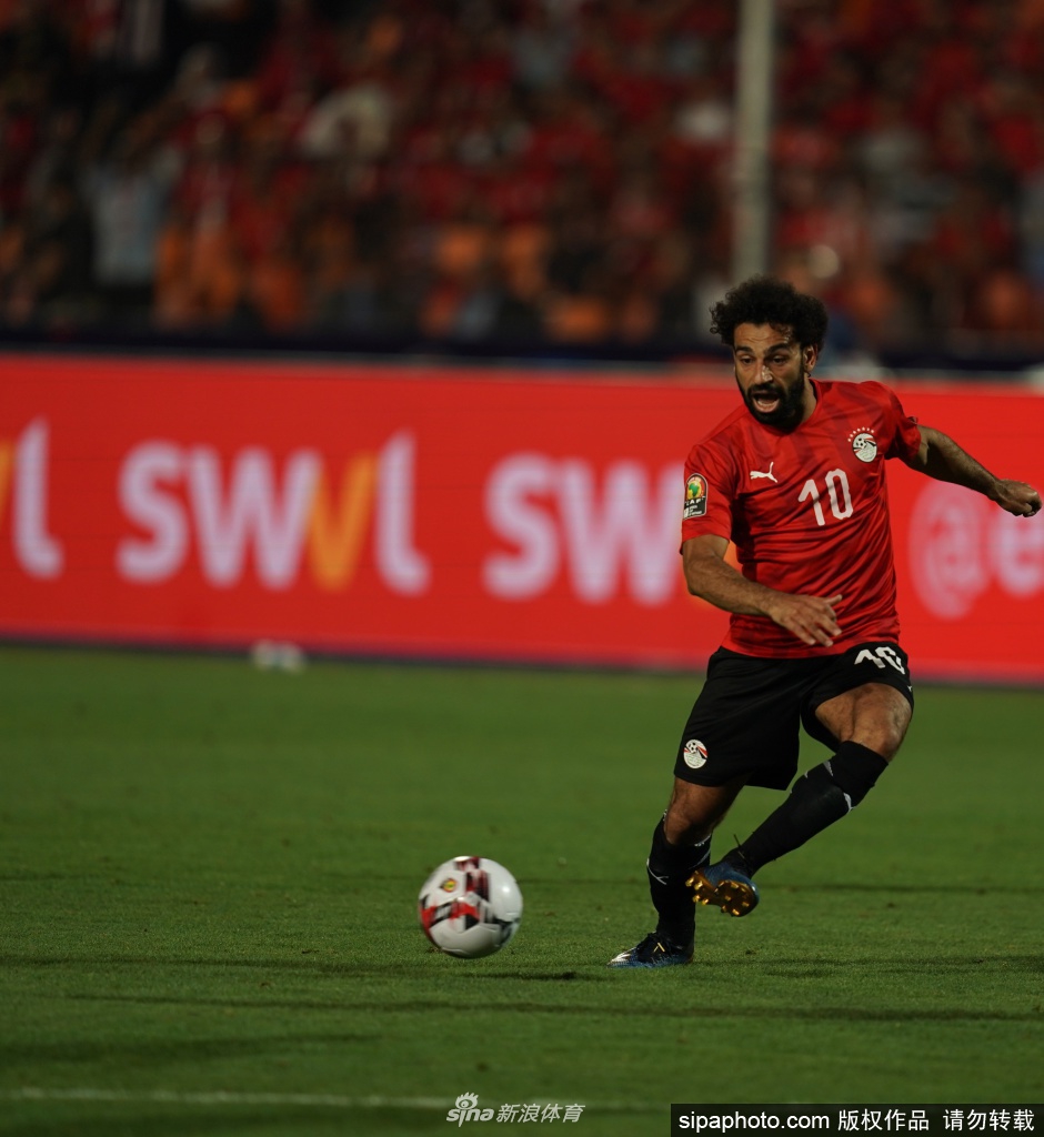 萨拉赫深情凝视着埃及国家队的队徽，指尖轻触胸前的五星标志，无声表达着对祖国的忠诚与热爱