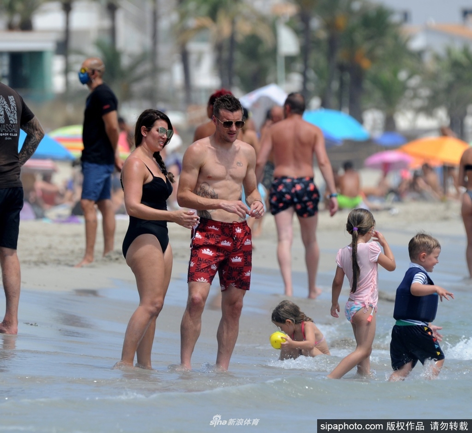 瓦尔迪戴着酷炫的飞行员墨镜，身着红色泳裤，双手叉腰站在西班牙金色海滩上，目光如炬地凝视着海面，仿佛在球场上观察对手一样，守护着正在海中嬉戏的孩子们，父爱如山在这一刻定格。