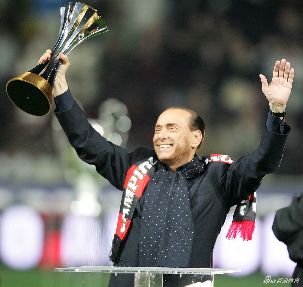 一张年轻时期的贝卢斯科尼在圣西罗球场抱着AC米兰球衣的珍贵照片，他的笑容灿烂，背后是他缔造的红黑王朝辉煌岁月，与如今面临的病毒挑战形成鲜明对比