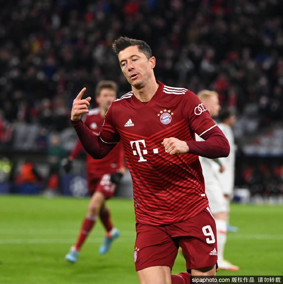 莱万打入第三球后张开双臂激情庆祝，背景中拜仁队友纷纷涌来分享历史性时刻