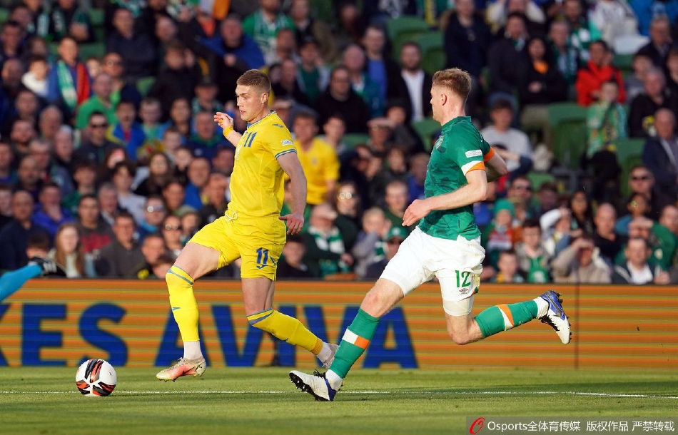 乌克兰队球员在比赛中激烈拼抢，身着黄色战袍的战士与绿色球衣的爱尔兰球员交织，展现高强度对抗。