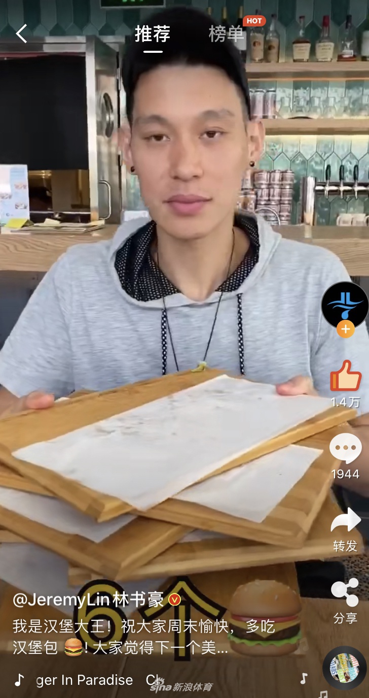 林書豪一手拿著吃了一半的漢堡，另一隻手比劃著數字，正在與旁邊滿臉笑容的漢堡店店員阿姨進行著有趣的對話，阿姨看他的眼神充滿了對“大胃王”的佩服。