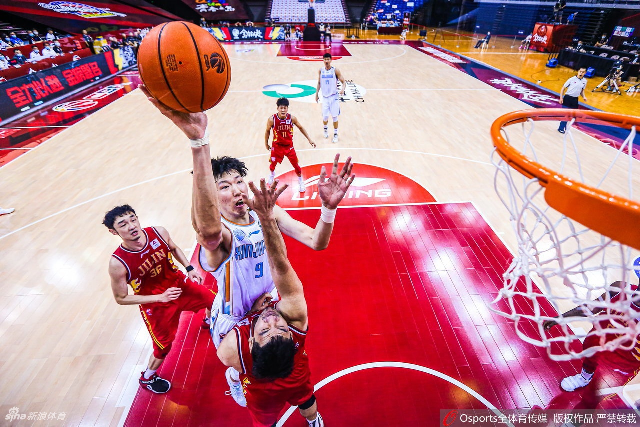 周琦在吉林队内线群中高高跃起，如探囊取物般摘下一个关键篮板，眼神中透露着必胜的坚定。