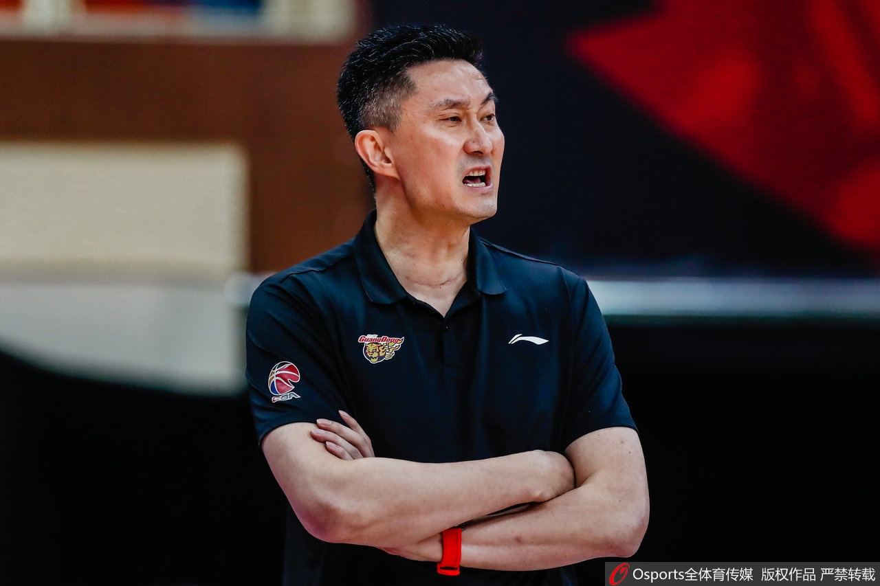 杜锋身着深色西装站在台上发表获奖感言,眼神坚定,手指微微抬起似在强调内心的信念