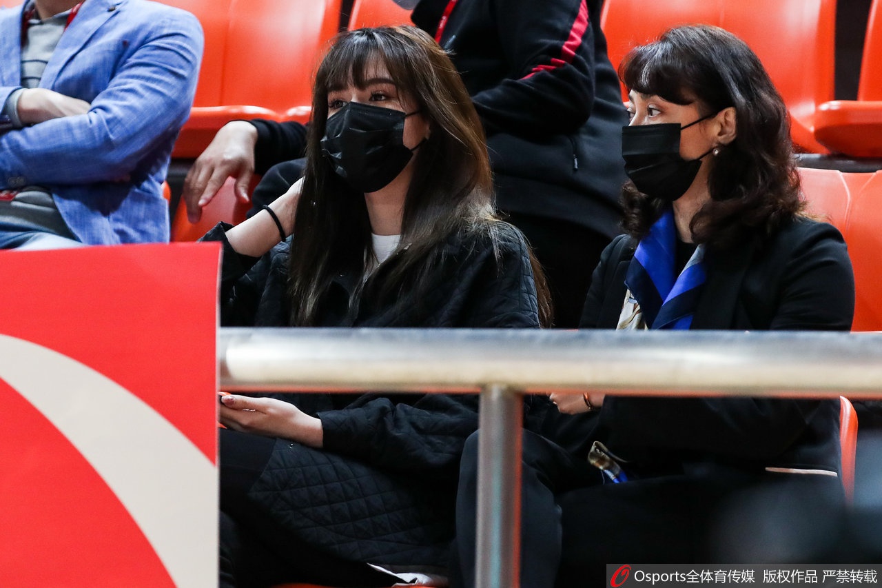 阿迪娜与母亲站在一起，两人均面带浅浅的笑意看向远处，阿迪娜的身高已经和母亲相当，母女情深在眼神中流露无遗。