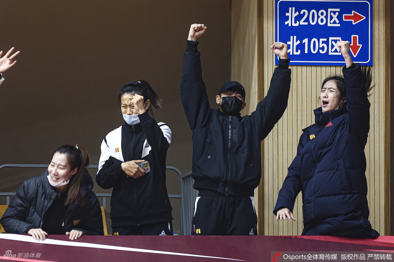 终场哨响,四川女篮球员们激动地拥抱在一起,庆祝这场来之不易的巅峰胜利,背景是大屏幕上的比分。