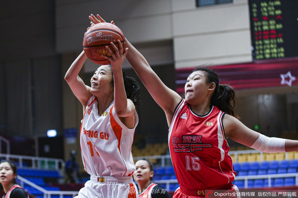 武汉女篮暂停期间，教练组围成一圈在白板上紧急布置战术，球员们弯腰倾听，眼神中透露出不甘与对下一次进攻的渴望。