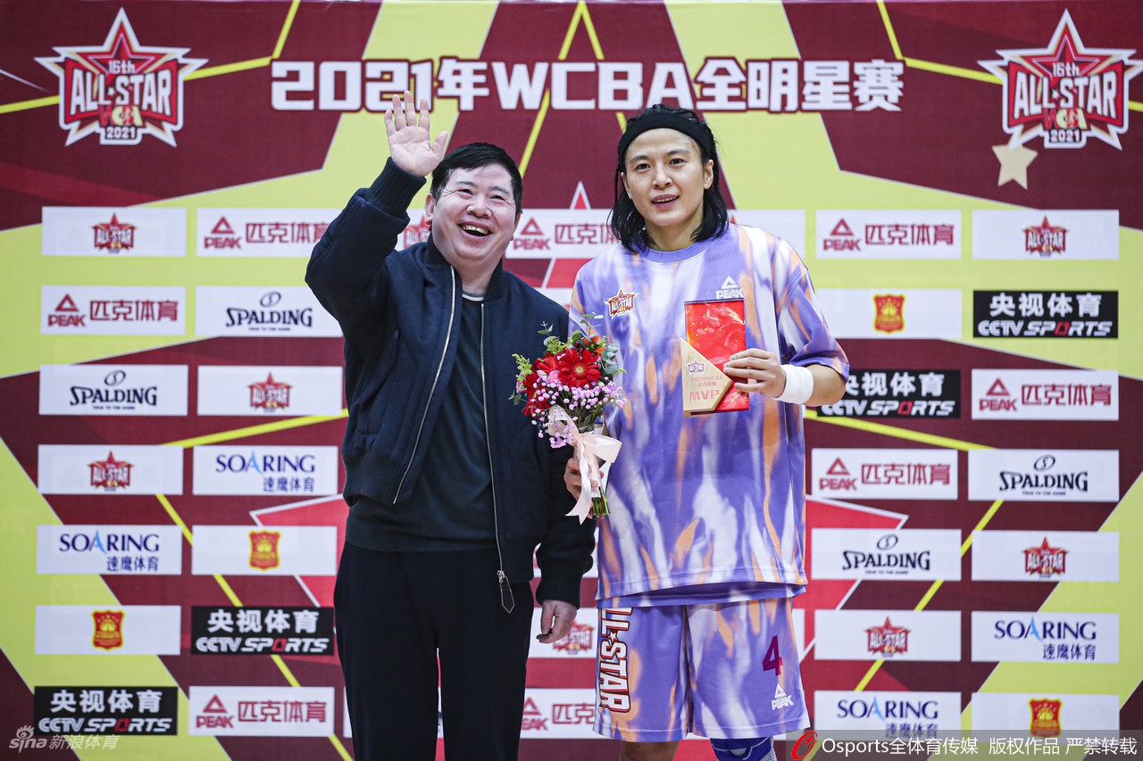 武桐桐高举三分球大赛冠军奖杯,脸上洋溢着自信的笑容,身后的队友和观众都在为她欢呼鼓掌