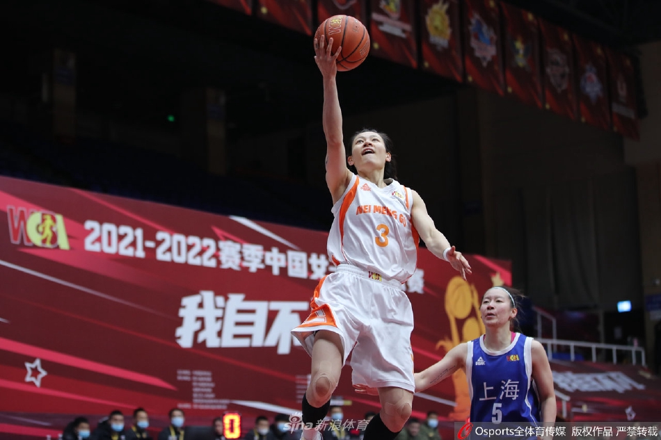 上海女篮队员在严密防守下强行突破,她面带专注,身体在空中尽力保持平衡,试图越过内蒙古队长臂的干扰完成上篮,拼搏精神令人动容。