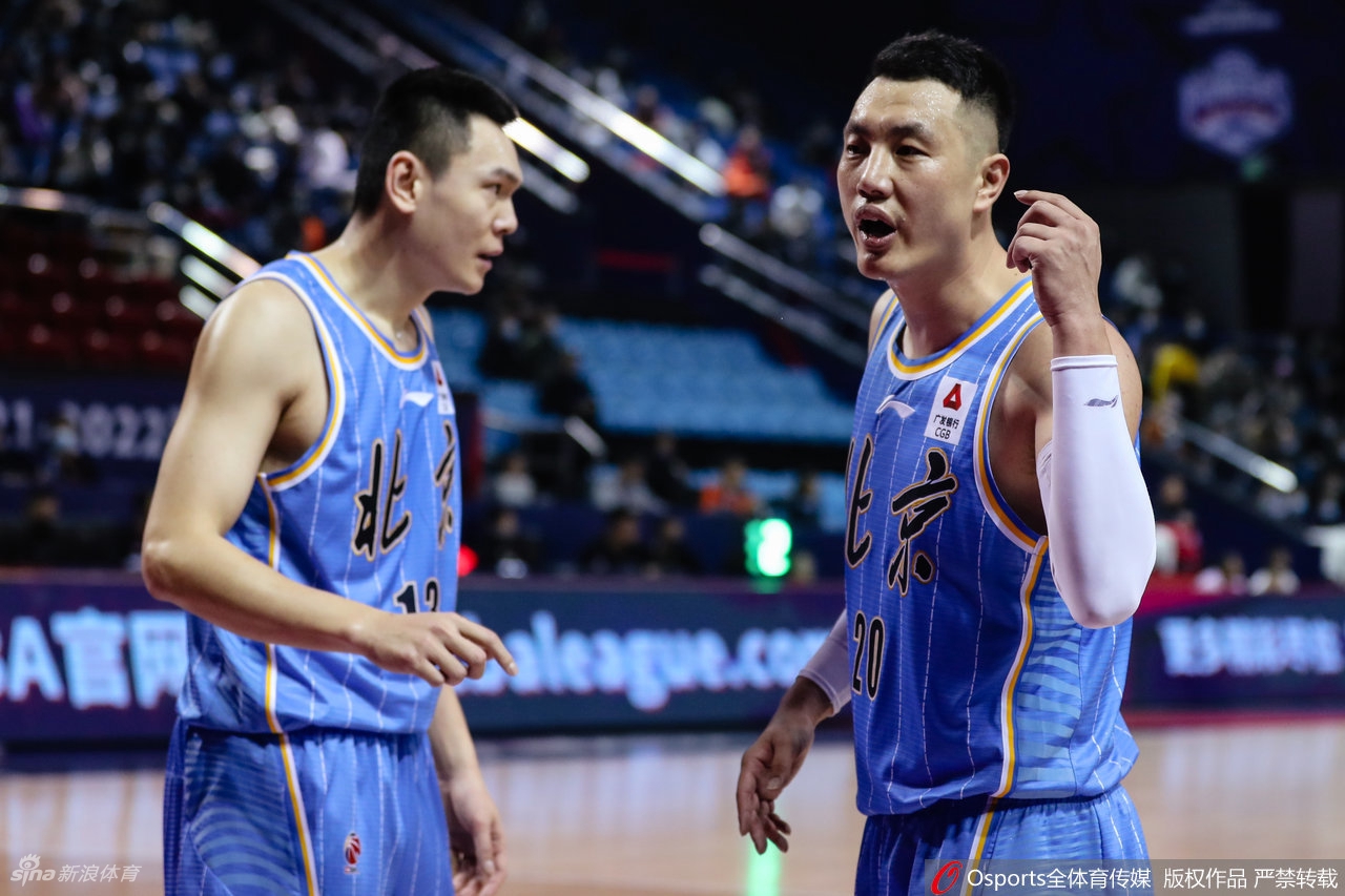 比赛场上，北京首钢队的球员们聚在一起，目光却齐齐望向场边的媒体席，原本激烈的比赛瞬间凝固，所有人的注意力都被这场意外的冲突所吸引