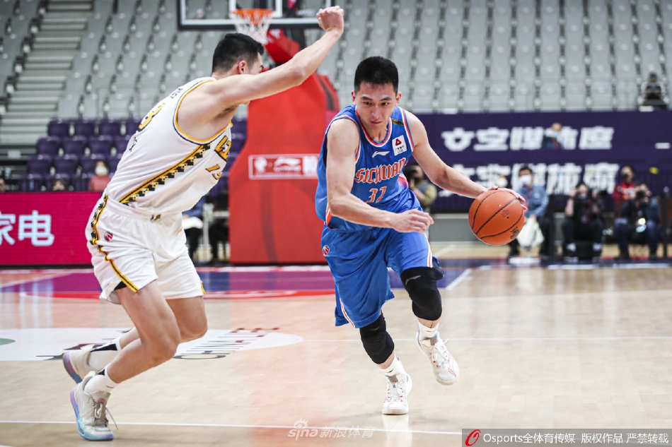 四川队球员袁振梁在篮下强起上篮，尽管身前有广厦防守球员的封盖干扰，他依然努力将球抛向篮筐，展现了不放弃的进攻欲望。