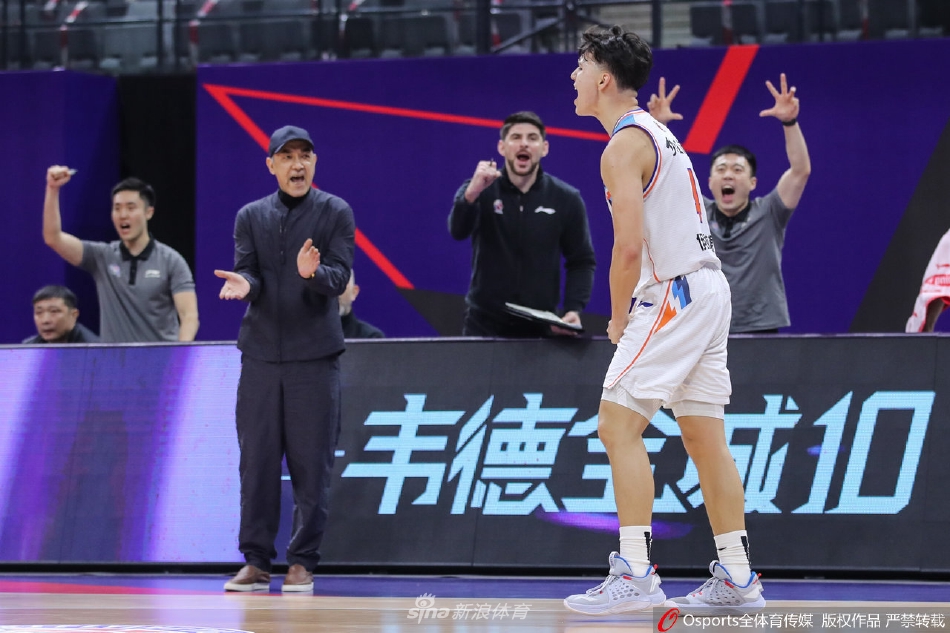 天津队内线张兆旭奋力跃起,试图封盖新疆球员的上篮,两人在空中形成激烈的身体对抗,肌肉碰撞之声仿佛穿透画面。