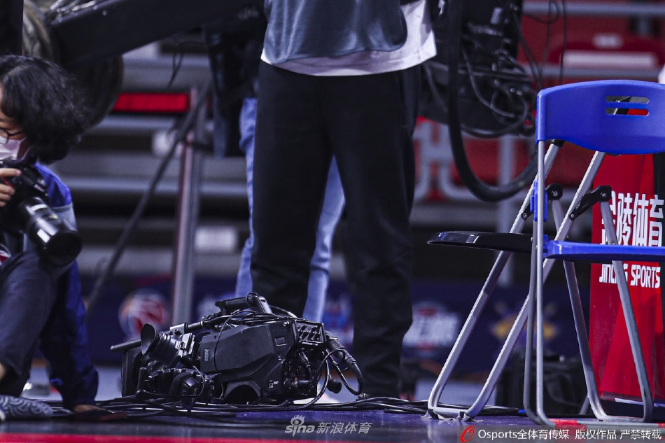 摔倒后的威姆斯试图从一片狼藉的记者席中撑起身子，他的手臂上出现了划痕，眼神却依旧倔强地盯着赛场方向，仿佛随时准备起身再战。