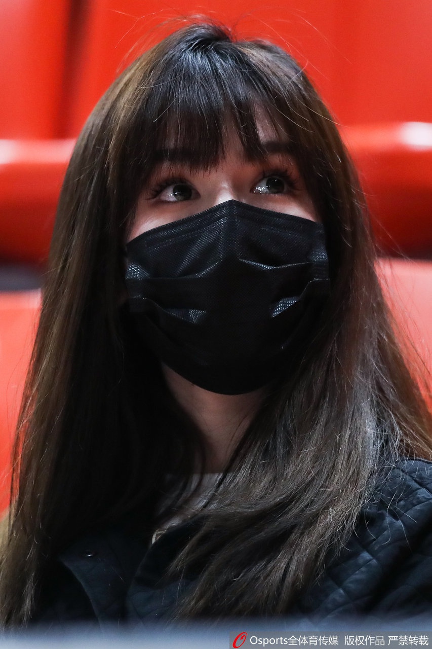 一张阿迪娜的面部特写，她轻轻撩起秀发，露出精致的侧脸线条，高挺的鼻梁和自然的唇色展现出毫无修饰的健康美。