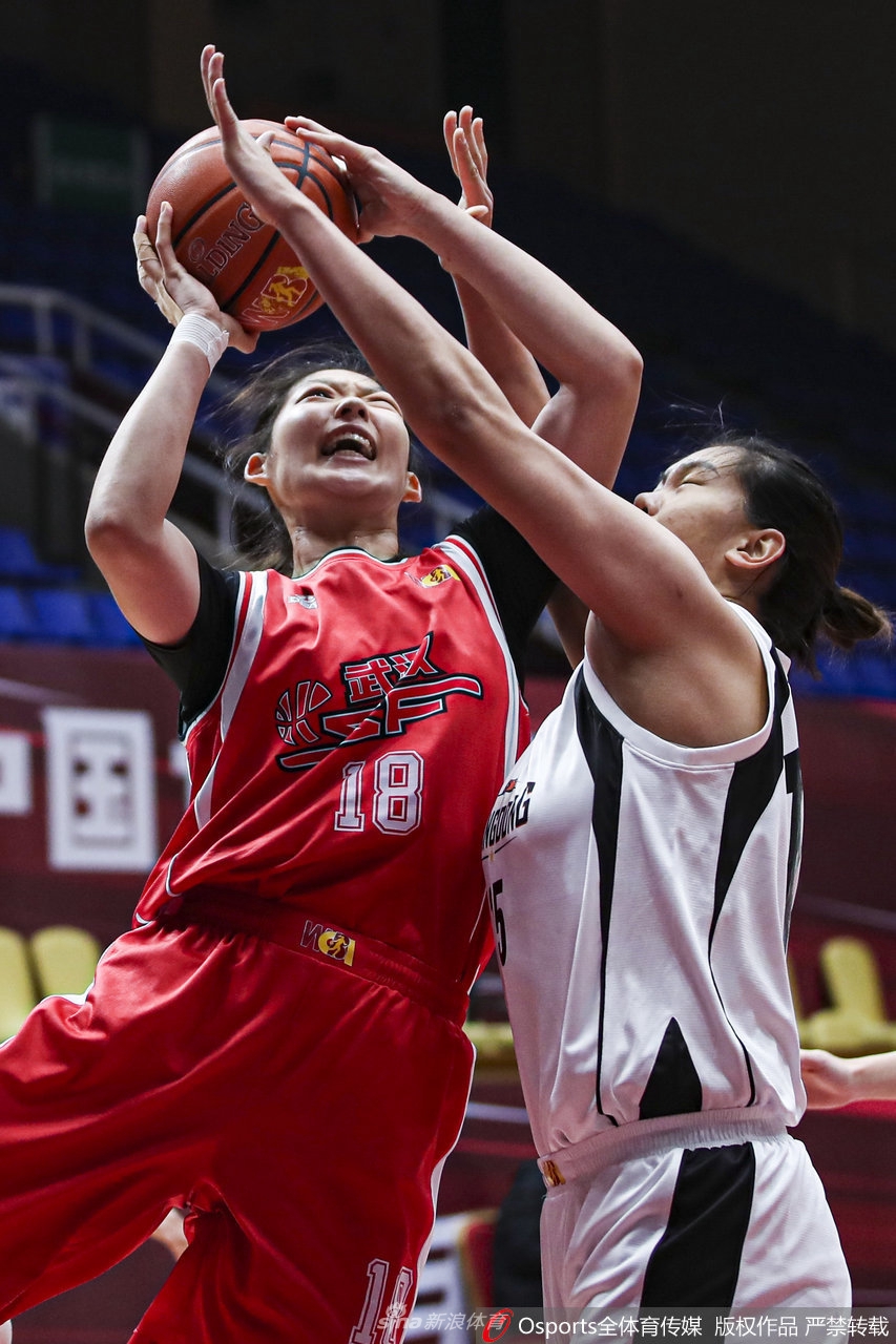 东莞队球员在多人包夹之下强硬上篮，她高高跃起，身体在空中形成一道弓形，奋力将球送向篮筐，展现出了极强的核心力量和对抗能力。