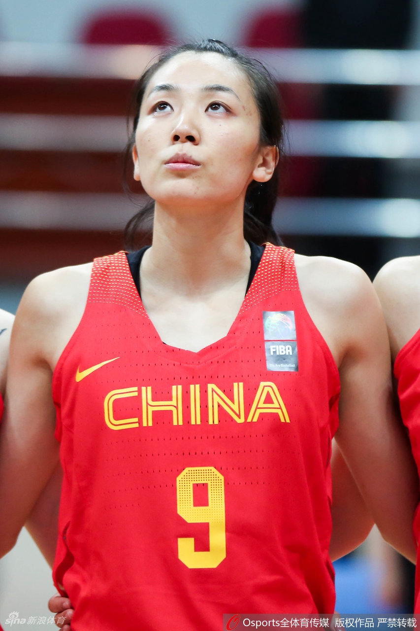 赵爽身披国家队战袍，在国旗下目光坚定，神情肃穆，展现出一名国手的荣誉感