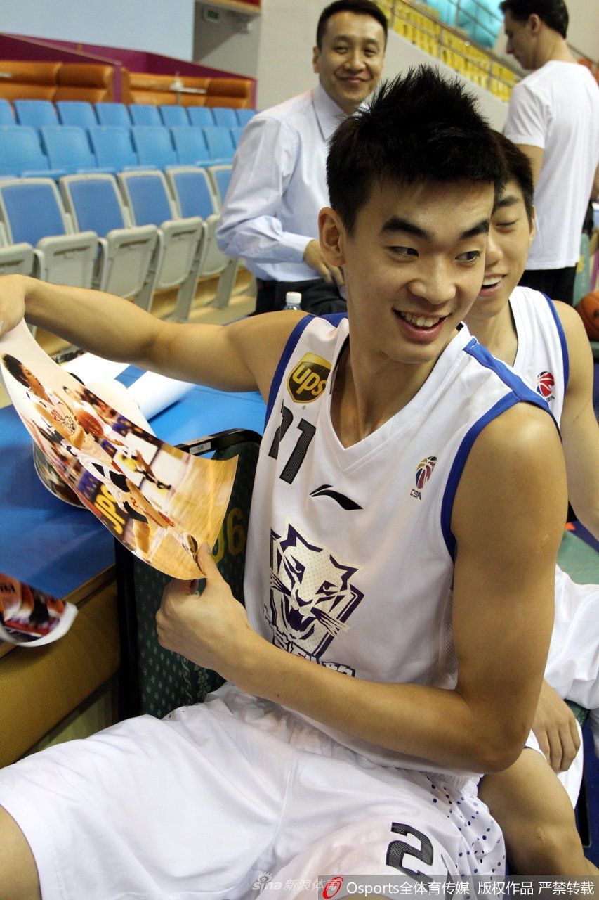 在北京首钢的休息区内，李慕豪用毛巾擦拭汗水，目光凝视着赛场，眼神中透露出坚毅与渴望胜利的决心。