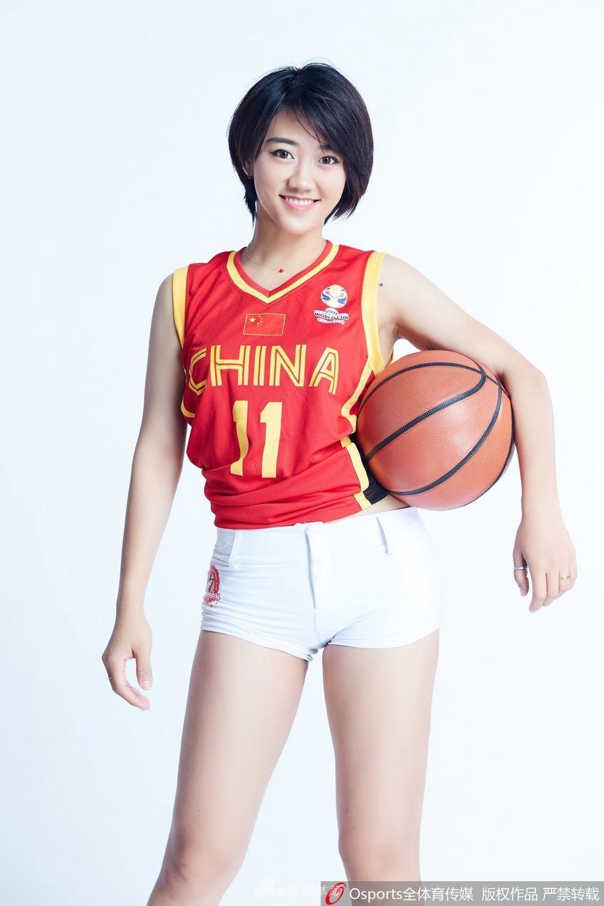 啦啦队员单手轻点唇边,另一只手在身前巧妙勾画出爱心的轮廓,眼神中流露出一丝俏皮与灵动,仿佛在告诉球员们放松心态,享受比赛。