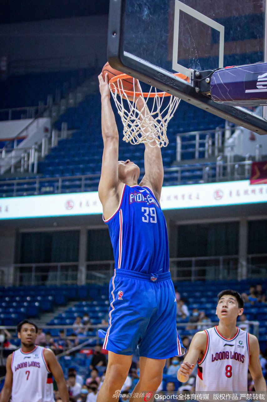 场边的篮球记者全神贯注地用相机记录赛场瞬间，他背后的天津队替补席神情紧张地关注着比赛。