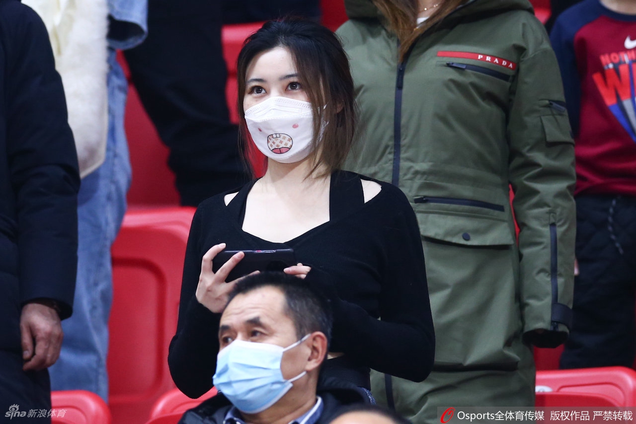 比赛暂停间隙，两位妆容精致的女球迷正在热烈讨论，其中一位激动地用手势比划着刚才的精彩进球。