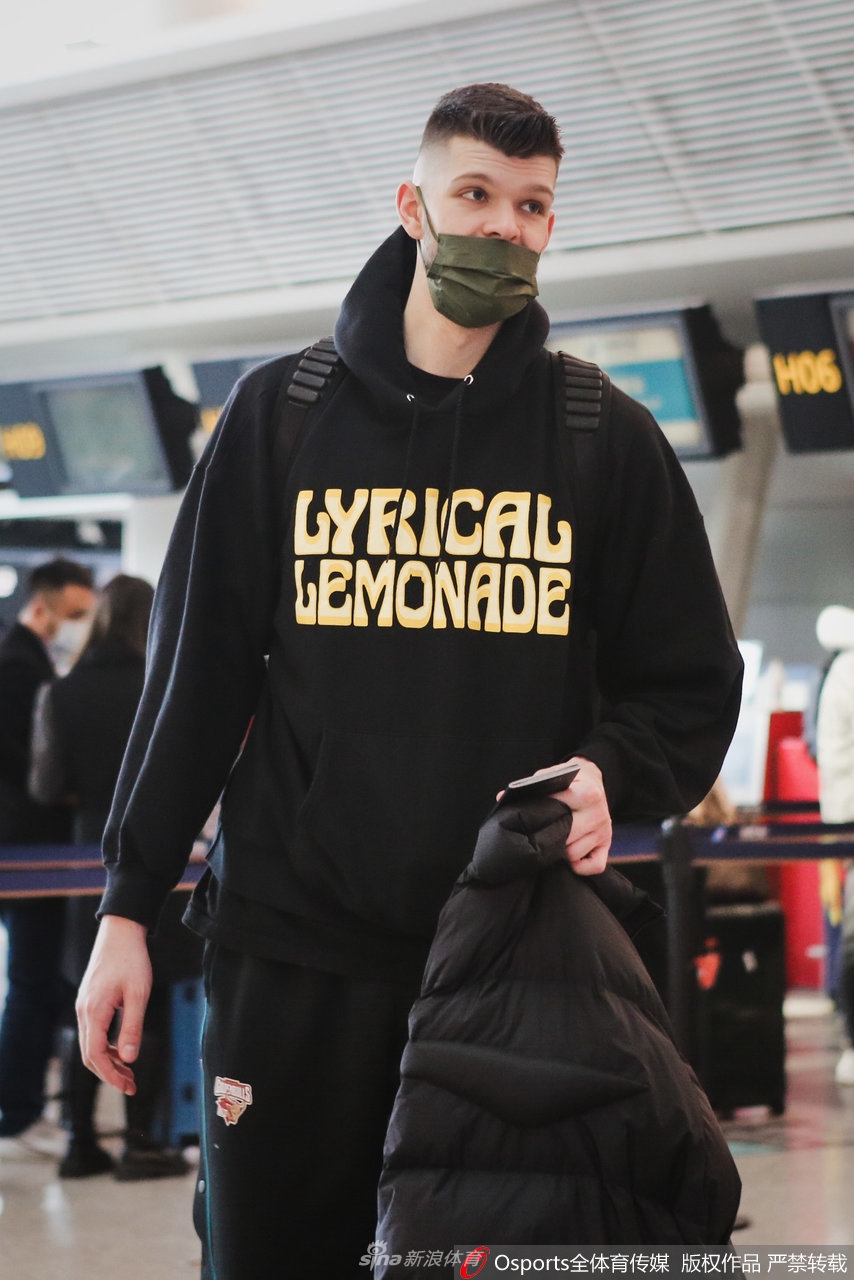 吴前站在值机柜台前,一手扶着行李箱的拉杆,另一只手仍在为身边最后一位球迷签名,白色的运动鞋和深色运动裤显得干净利落,人群中他的专注仿佛隔绝了周遭的喧嚣。