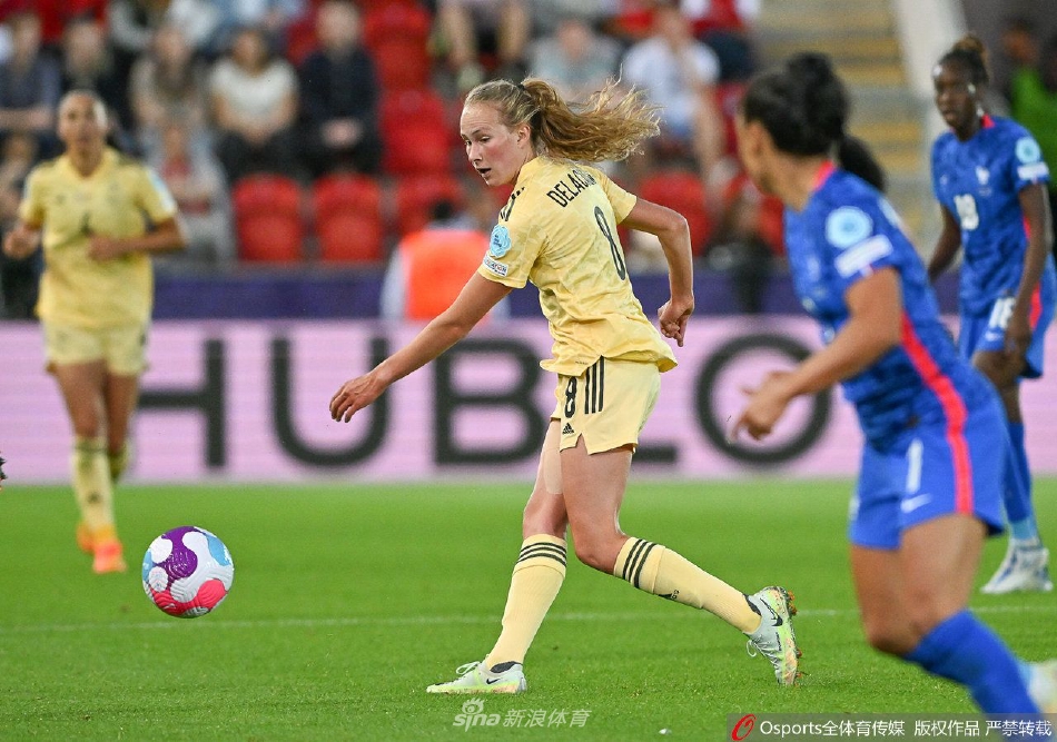 比利时队球员雅尼丝·凯曼破门后与队友激动相拥庆祝，她们的脸上写满了扳平比分的兴奋与坚定。