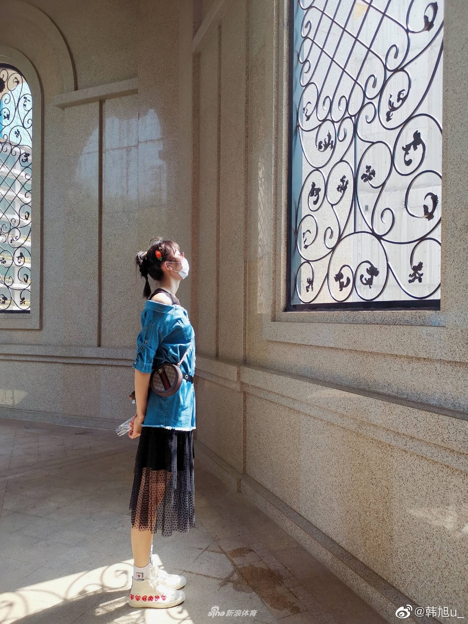 韩旭以都市街景为背景，随意撩动秀发，眼神中透露出自信与从容，完美展现了高个子女生也能拥有的时尚表现力。